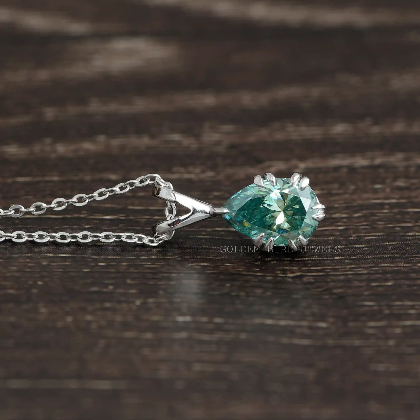 Side view of pear cut moissanite solitaire pendant