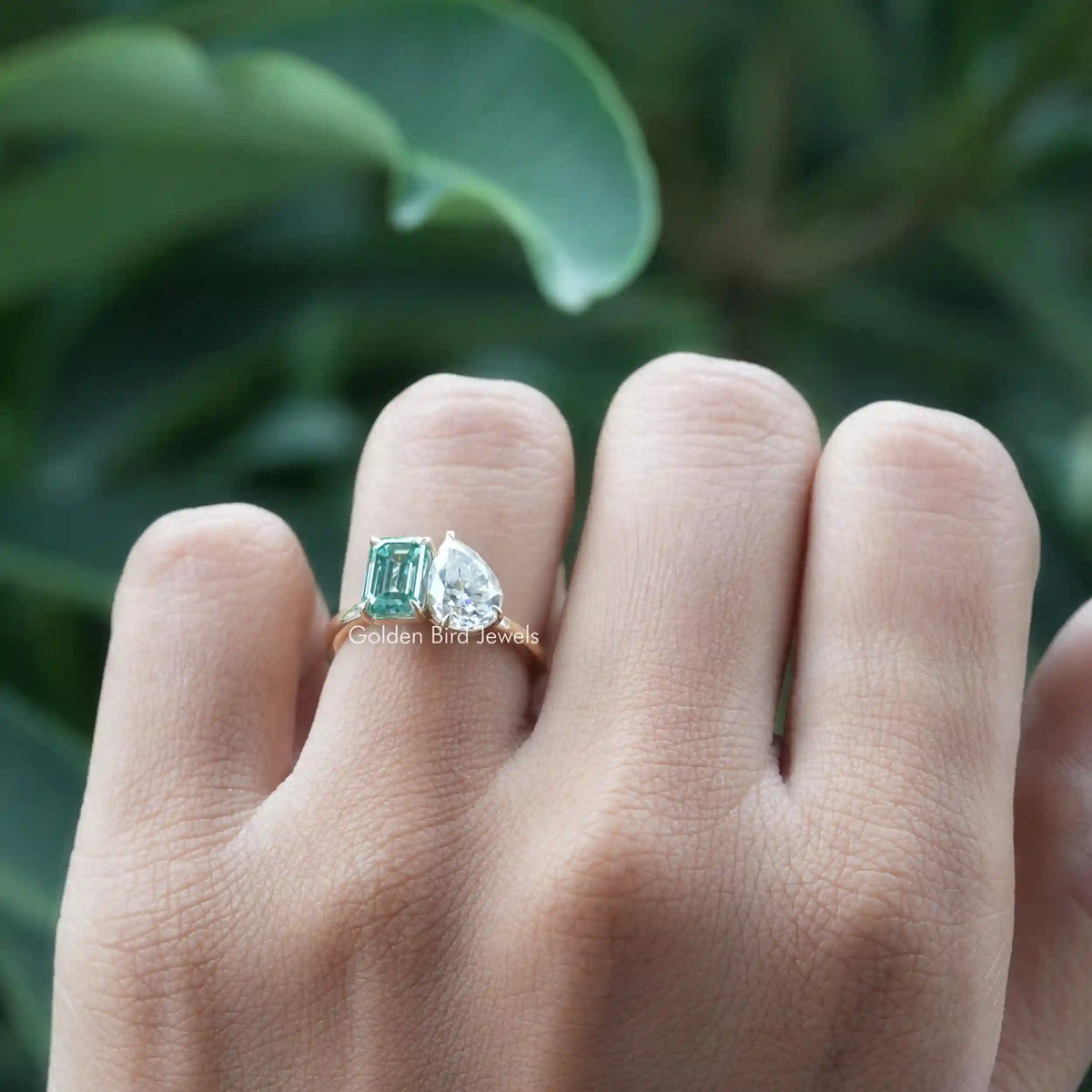 Detailed view of two-stone pear and emerald cut moissanite ring.