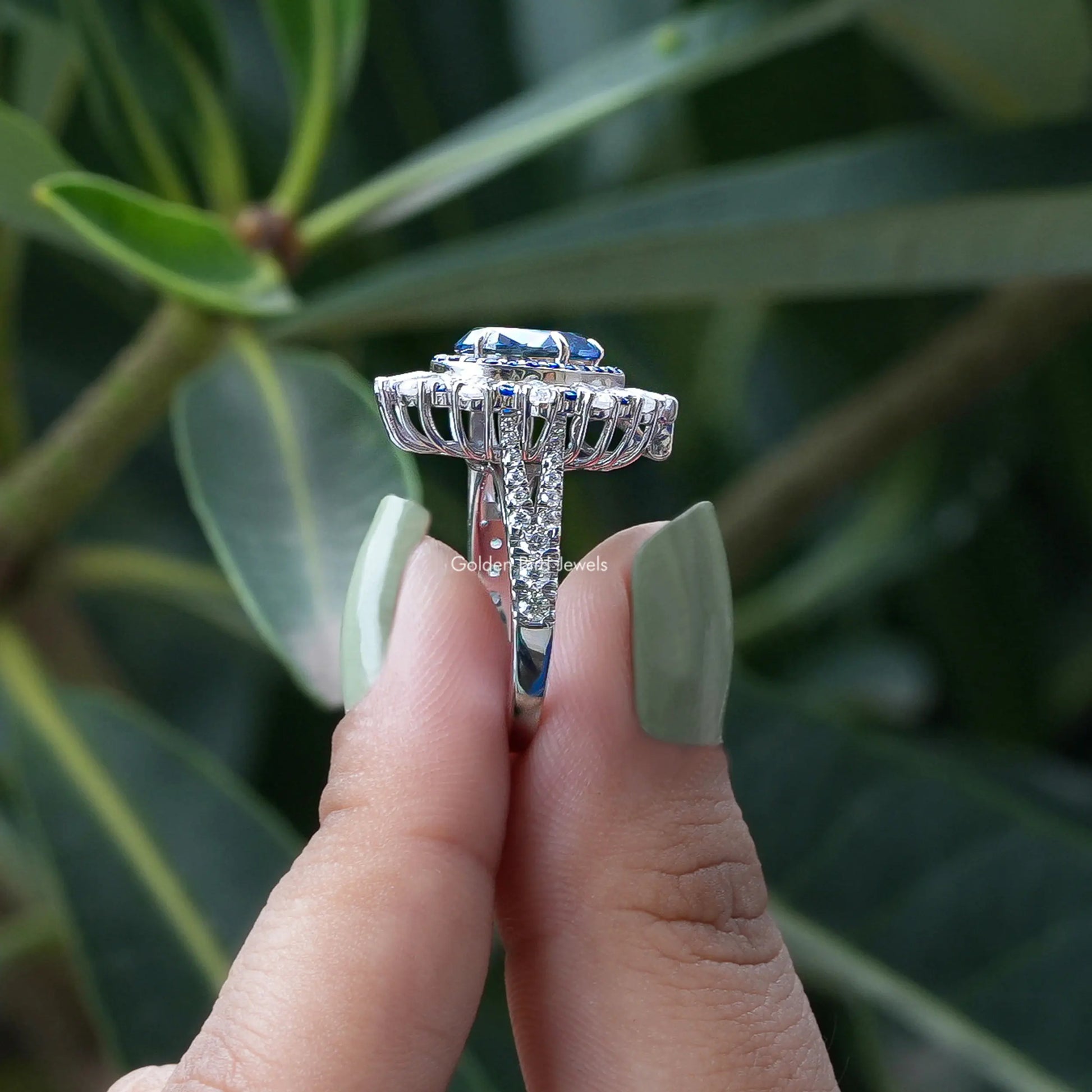 Side View of Double Halo Pear Shaped Moissanite Ring In two fingers