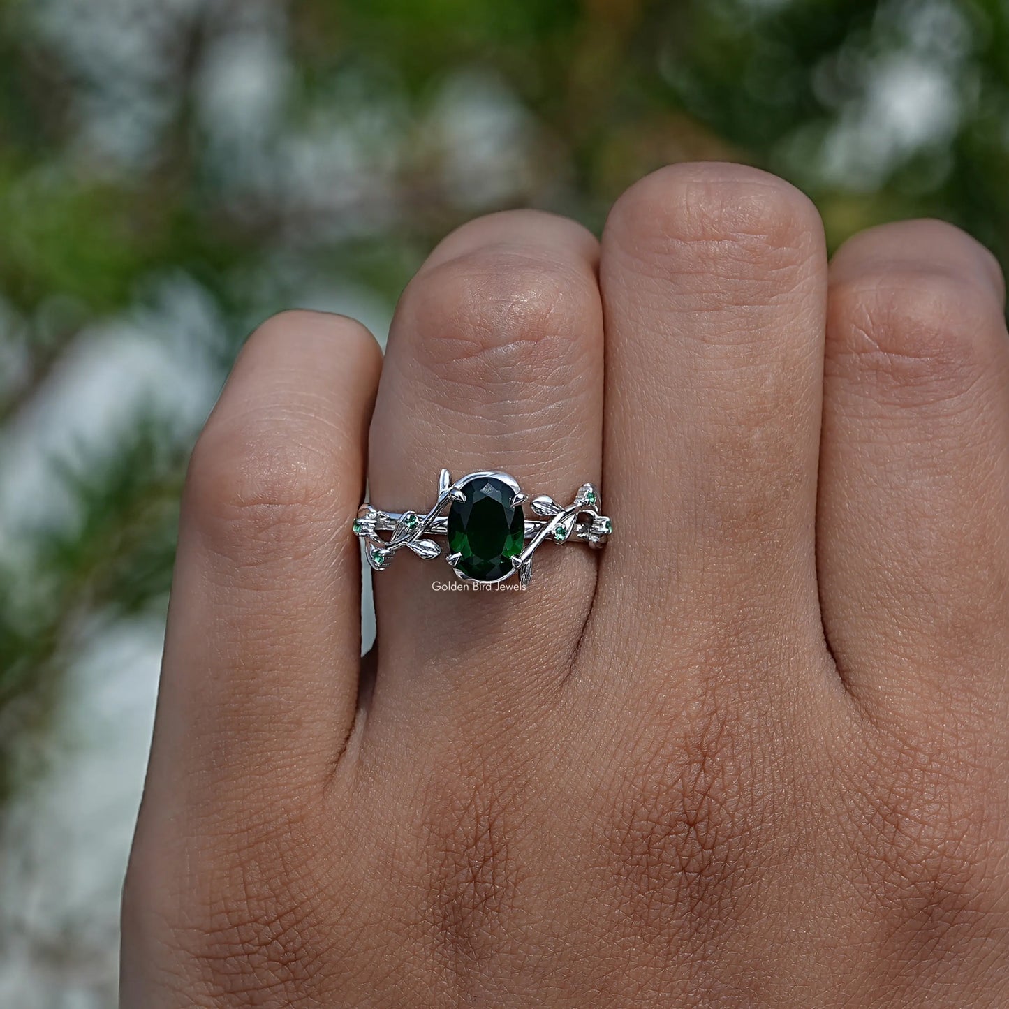 Close-Up View of Green Oval Cut Gemstone Engagement Ring In White Gold