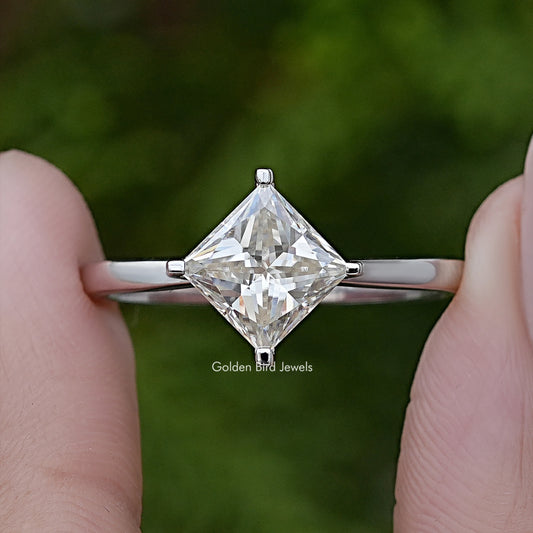 Princess-cut solitaire engagement ring with clear center stone, four-prong setting, silver band