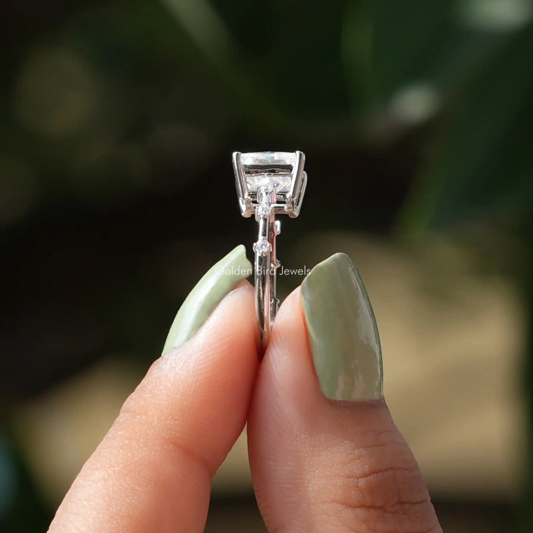 Side View of Princess And Round Cut Moissanite Ring In two fingers