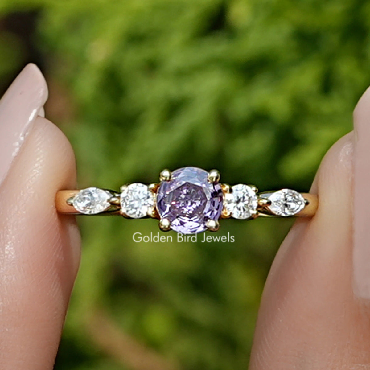 Front view of Amethyst Round Cut Gemstone Accent Ring in two fingers 