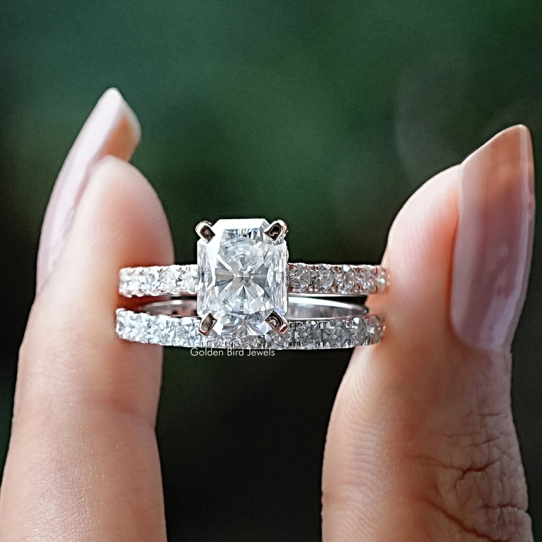 Two fingers holding the Radiant Cut Moissanite Bridal Ring