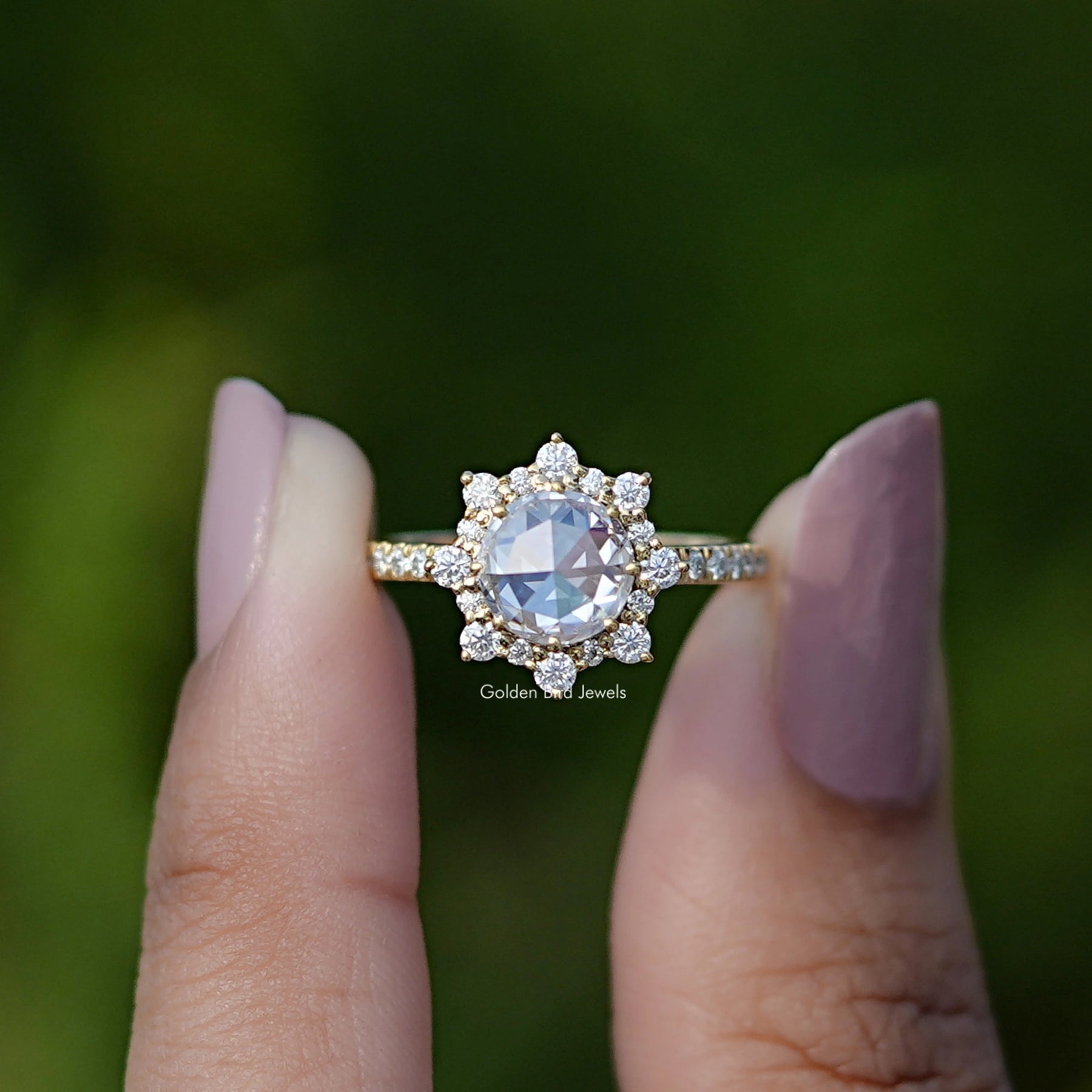 Two fingers holding the Rose Cut Round Halo Moissanite Ring