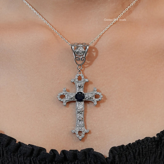 Silver-tone cross pendant necklace with dark round gemstone center and side accents