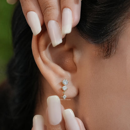 Gold-tone three-round-stone stud earring with round lab diamonds, on ear