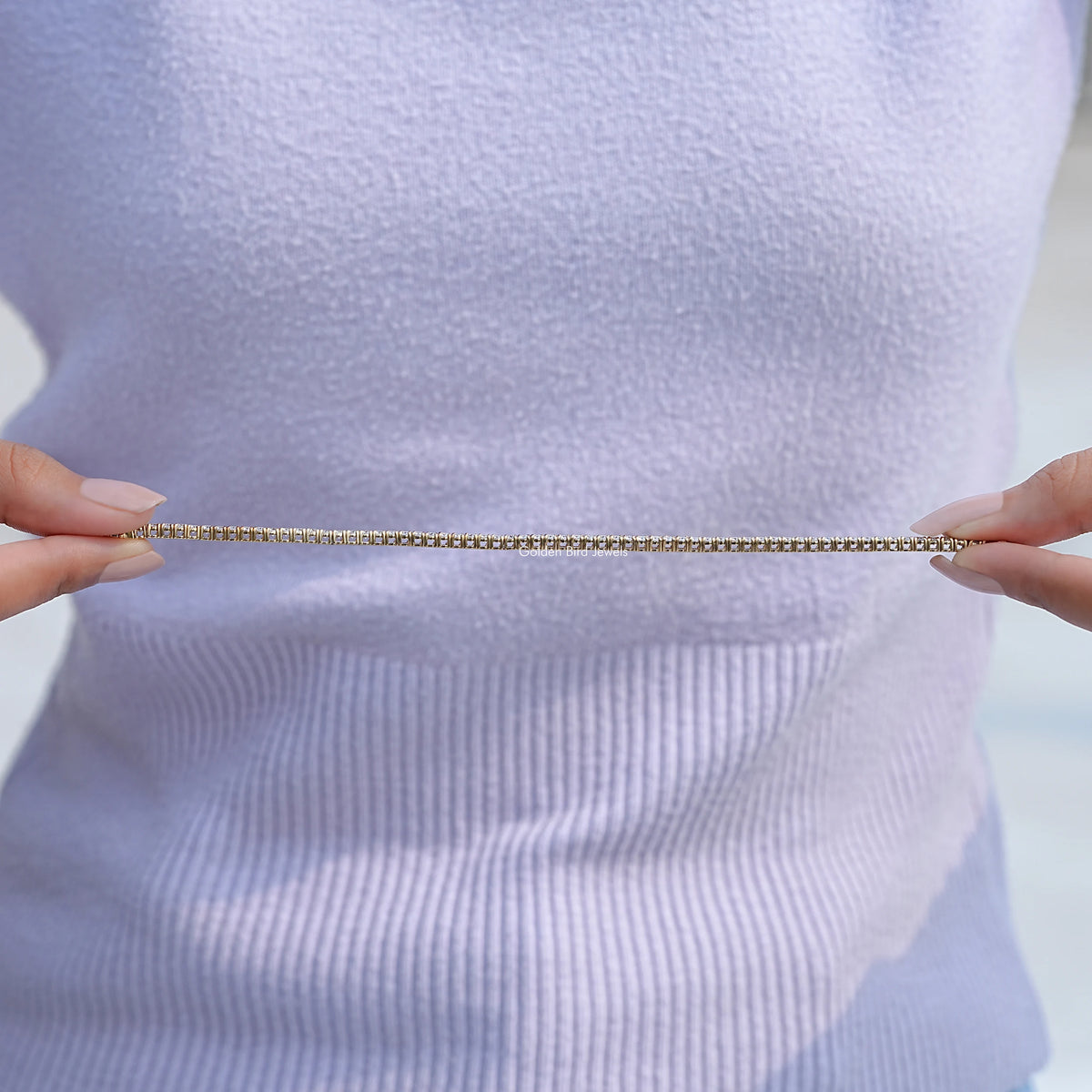 Round-cut tennis bracelet laid flat, clear stone rows across