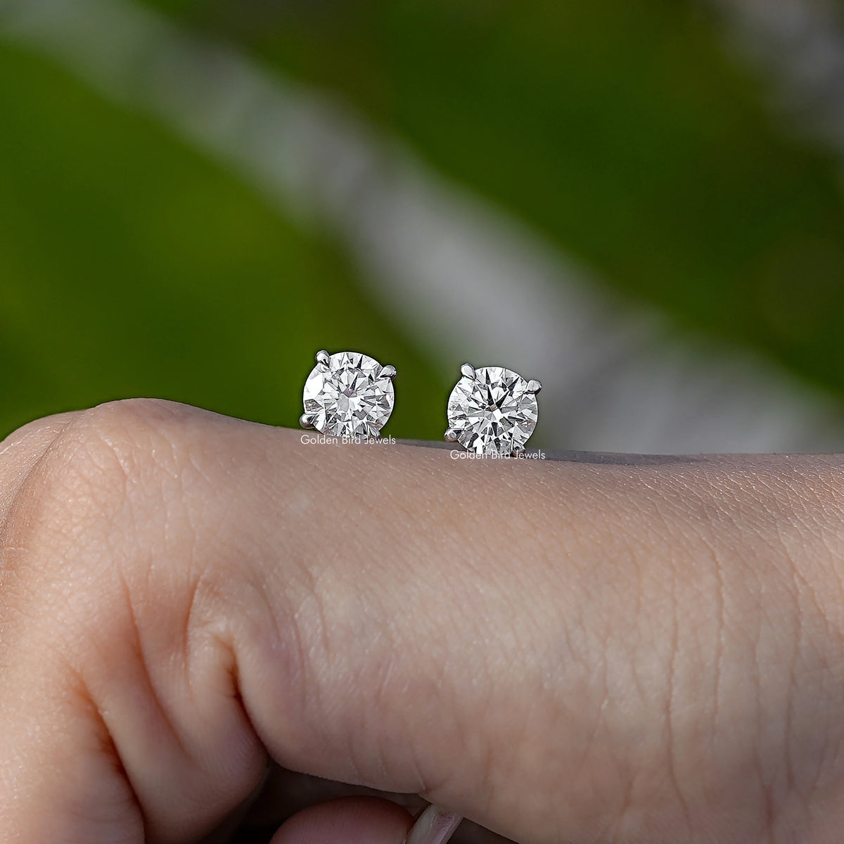 Pair of round-cut solitaire stud earrings with clear stones in silver-toned settings