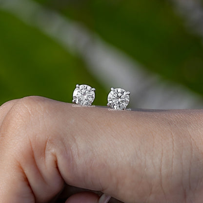 Pair of round-cut solitaire stud earrings with clear stones in silver-toned settings