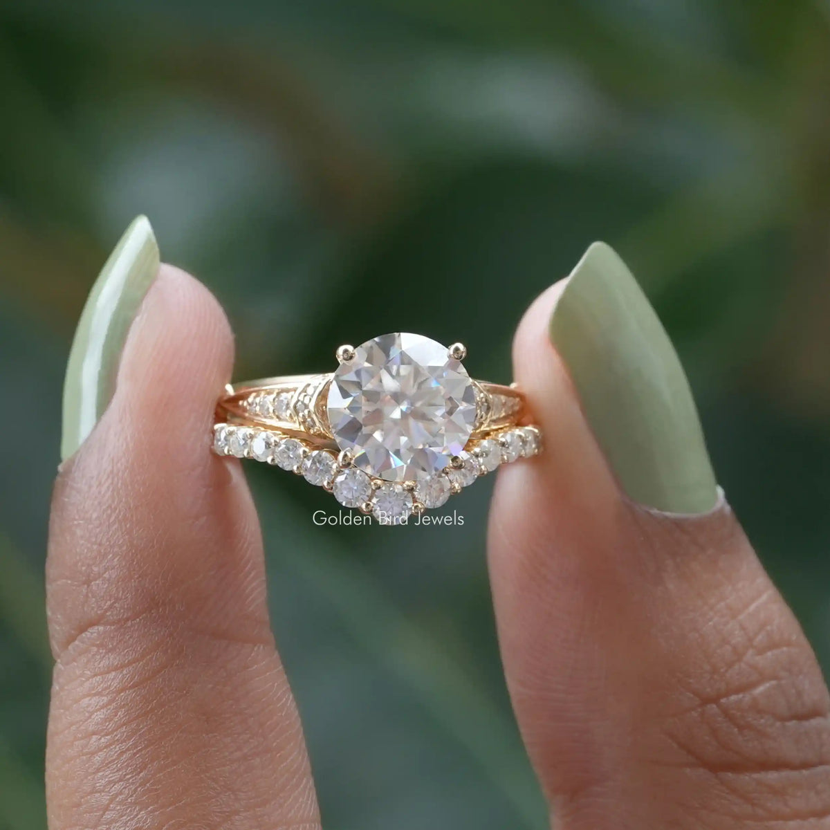 Two fingers holding the Round Cut Accent Stone Moissanite Engagement Ring