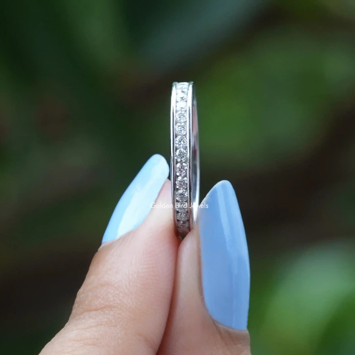 Side View of Channel Set Round Cut Moissanite Band In two fingers