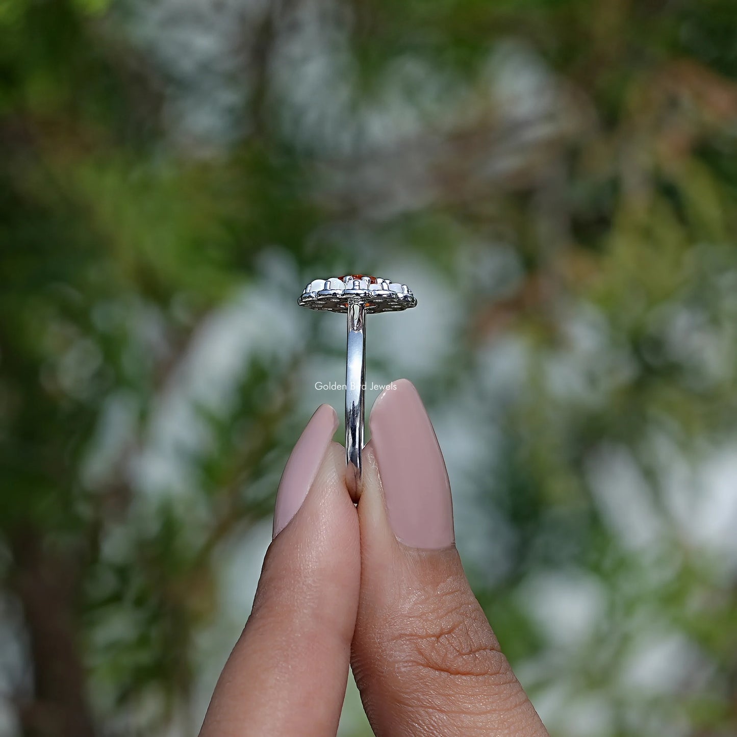 Side View of Round Cut Engagement Ring In two fingers