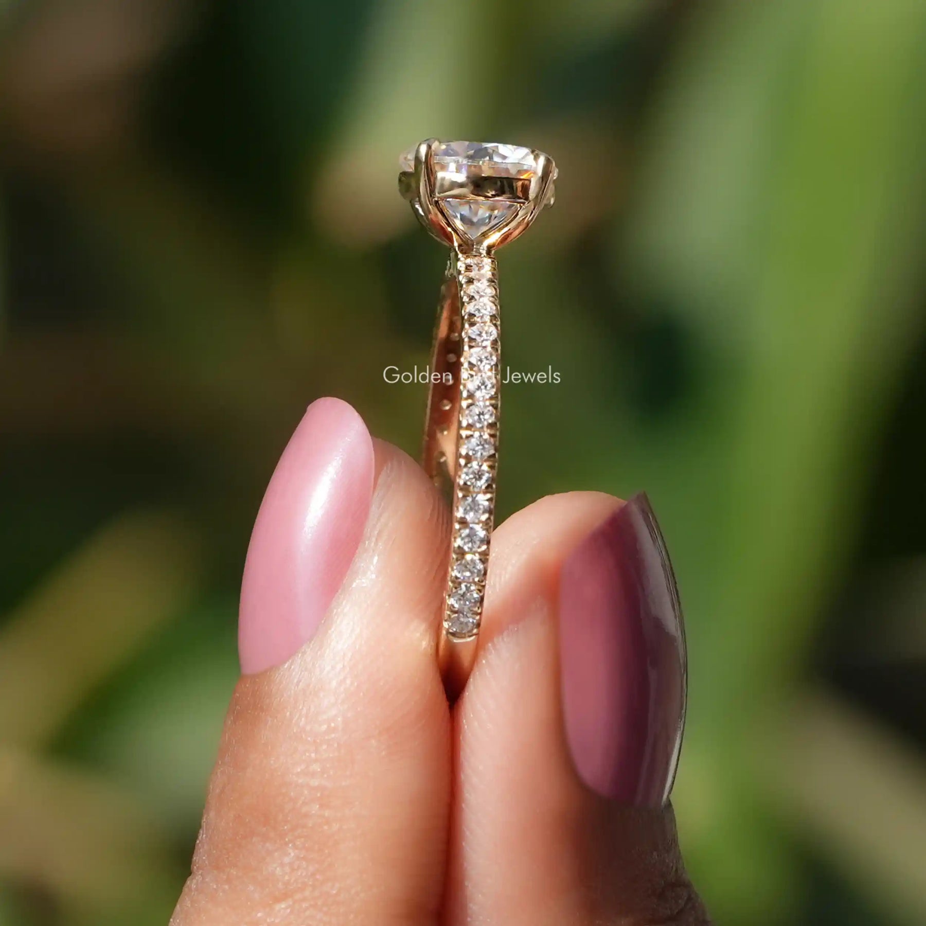 Side View of Round Cut Moissanite Solitaire With Accent Ring In two fingers