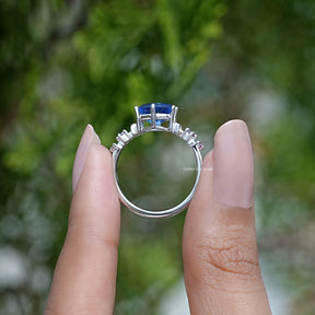 Back View of Blue Hexagon Engagement Ring With Round Stone In two fingers