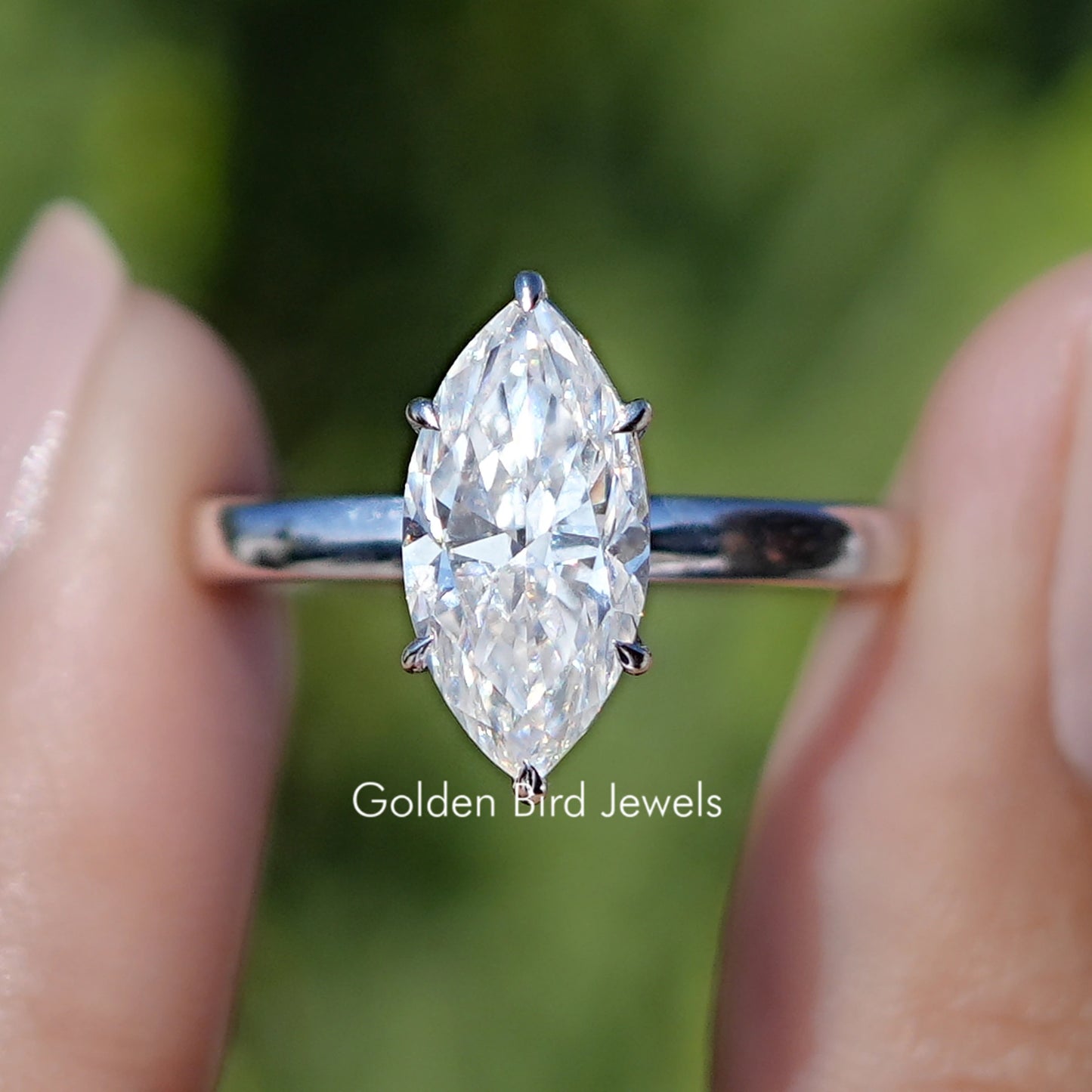 Front view of Red Marquise Cut Moissanite Hidden Halo Wedding Ring Set in two fingers 
