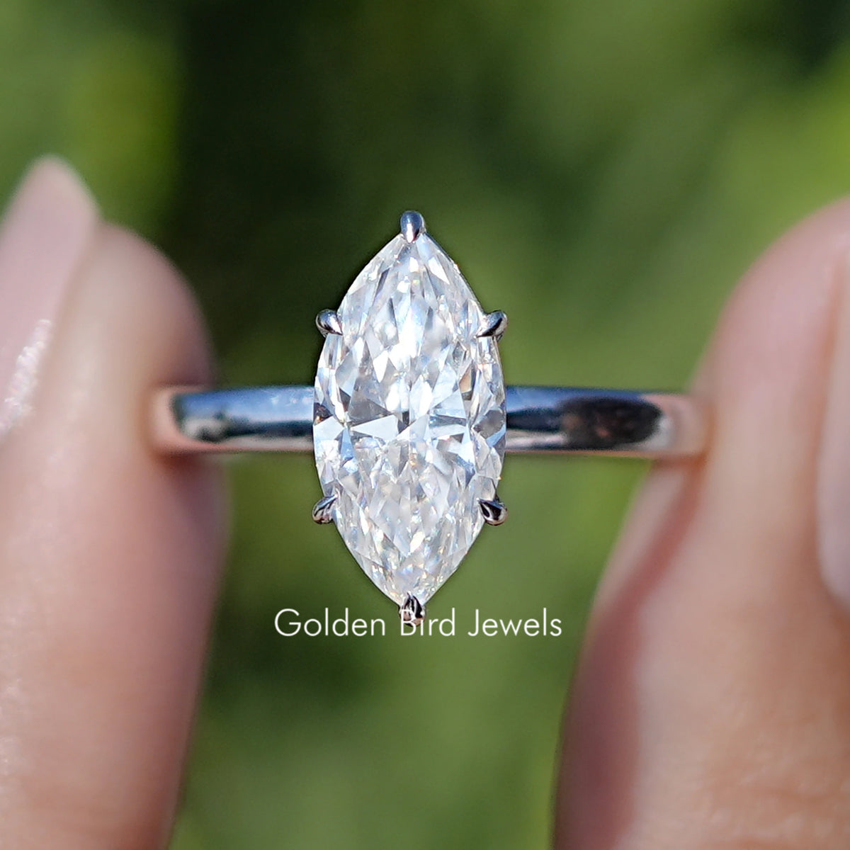 Front view of Red Marquise Cut Moissanite Hidden Halo Wedding Ring Set in two fingers 
