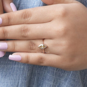 [In hand front view of dutch marquise cut moissanite engagement ring set in bezel]-[Golden Bird Jewels]