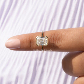 In finger front view of Half Bezel Set Emerald Cut Engagement Ring In White Gold