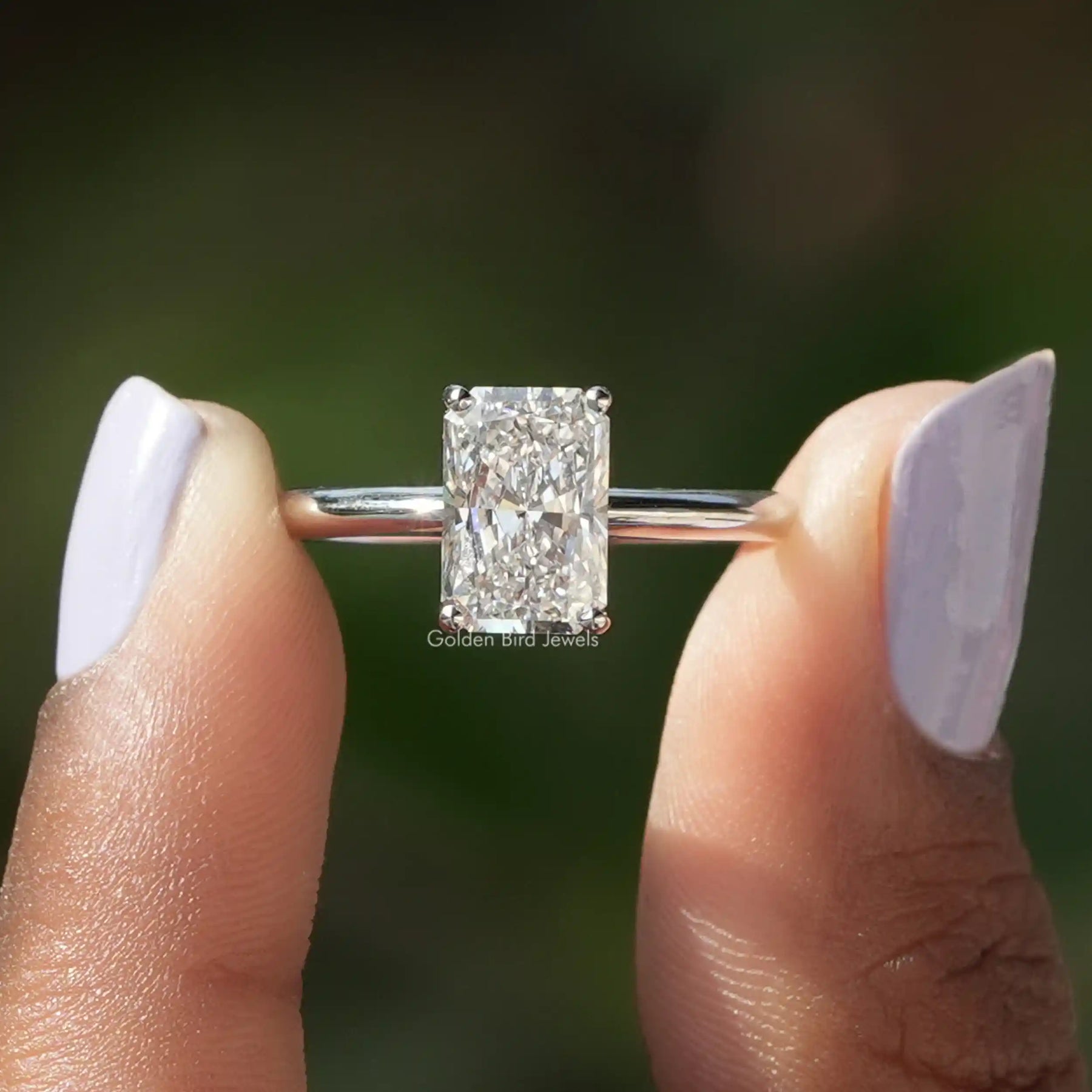 Two fingers holding the Radiant Cut Solitaire Diamond Engagement Ring