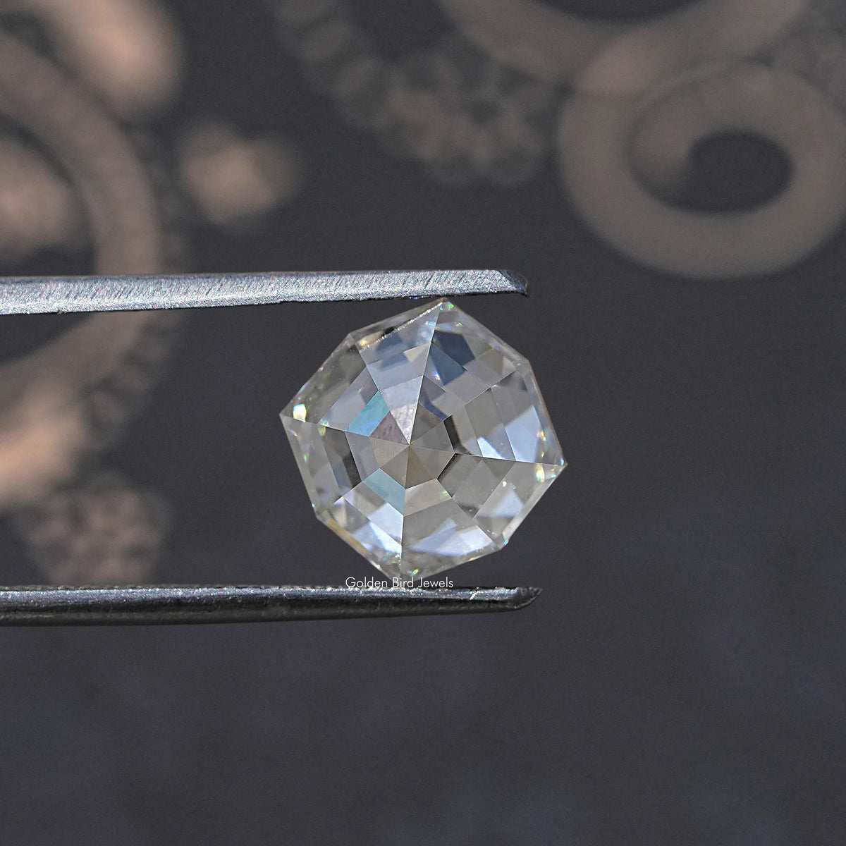 Colorless cushion-cut moissanite loose gemstone, close-up held by metal tweezers.