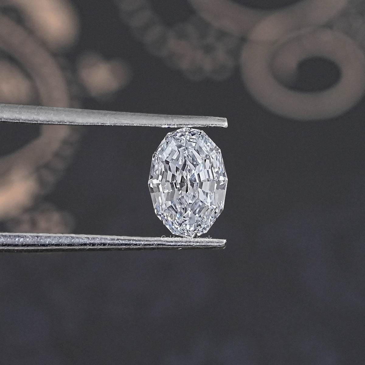 Loose lab-grown oval diamond held between metal prongs, step-cut facets