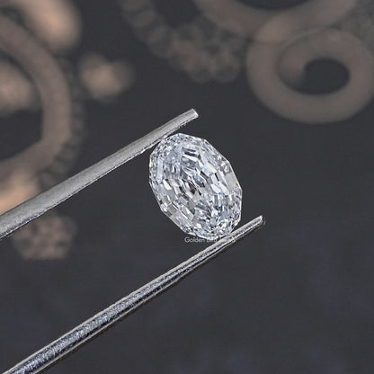 Loose lab-grown oval diamond held in tweezers, step-cut faceting close view