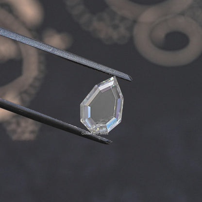 Faceted clear moissanite loose gemstone held with metal tweezers, step-cut style.
