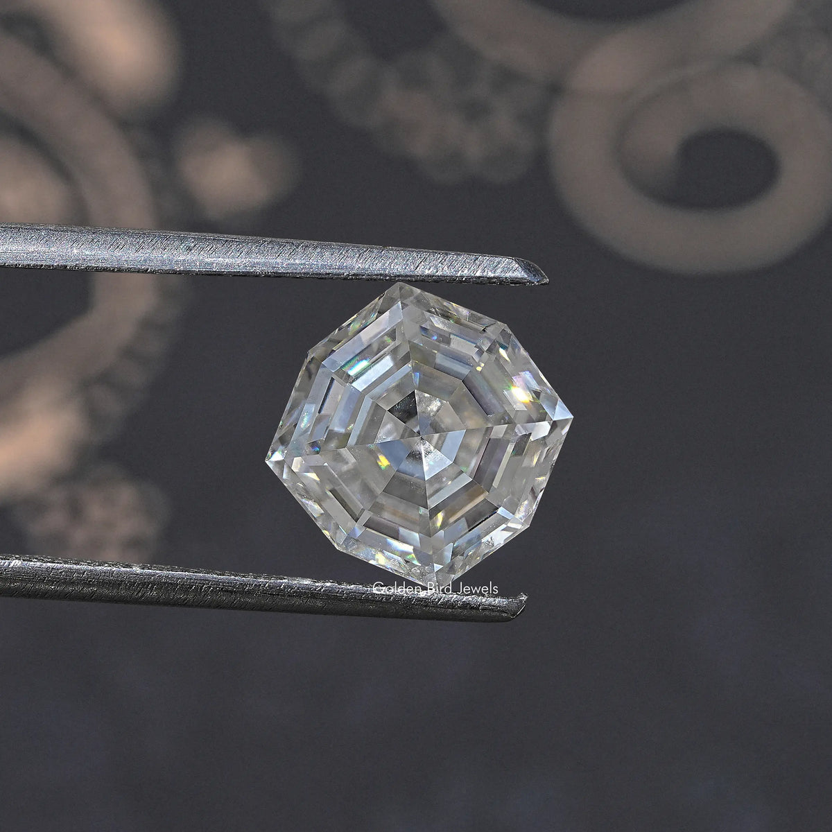 Colorless cushion-cut moissanite loose gemstone held by metal tweezers, angled close-up.