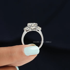 Back view of Three stone moissanite ring holding on two fingers